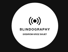Crno-bijeli logo u obliku kruga sa stilizovanim simbolom valova u sredini. Ispod simbola nalazi se natpis 'BLINDOGRAPHY', a ispod toga manjim slovima piše 'DODIROM KROZ SVIJET'.